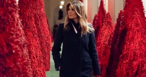 Melania Trump megtekinti az áfonyából készült karácsonyfákat – vagy ahogy egyes amerikai lapok lenevezték: a vérfenyőket (Fotómontázs két képből, amelyek ugyanott, ugyanakkor készültek. Célunk Melania „boldog" arcának kihangsúlyozása volt)